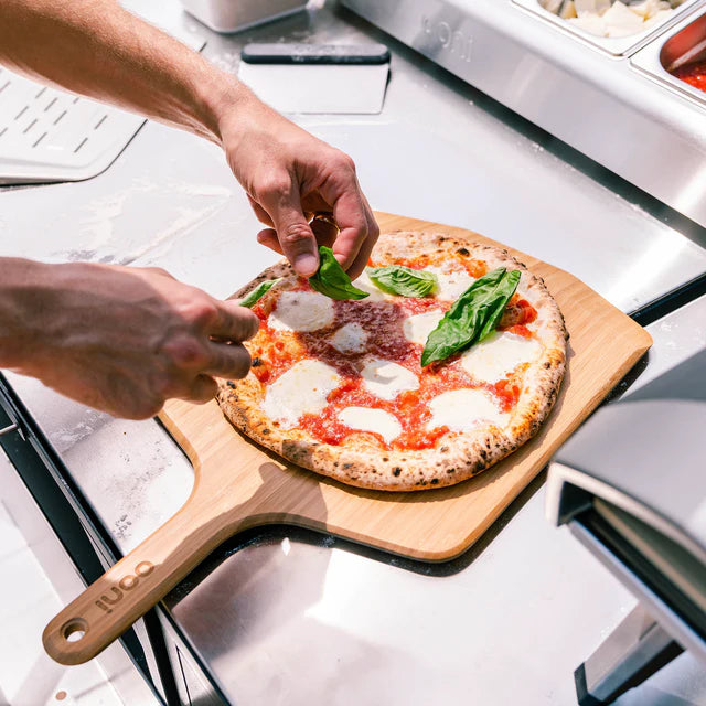 Belegen der Pizza auf der Ooni Holz-Pizzaaschaufel